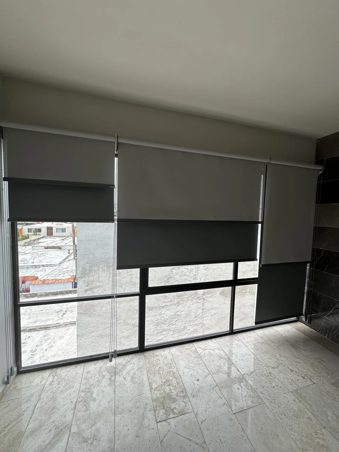 Dos persianas enrollables independientes sobre una ventana, instalación real